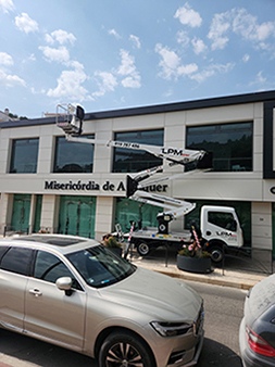 Camião LPM Rent com plataforma elevatória em manutenção num edifício comercial no Carregado - Serviços de elevação e limpeza de fachadas